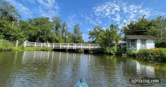 Long white bridge over a canal seen from a kayak.