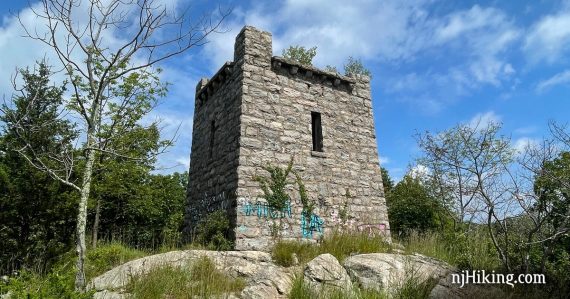 Ruins of a stone water tower on a rocky area in a forest