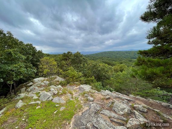 View of green mountains beyond a rocky outcrop