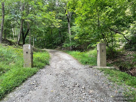 Cement pillars flanking a gravel driveway