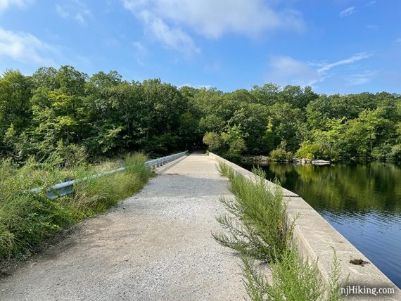 Long flat concrete dam at the end of a lake