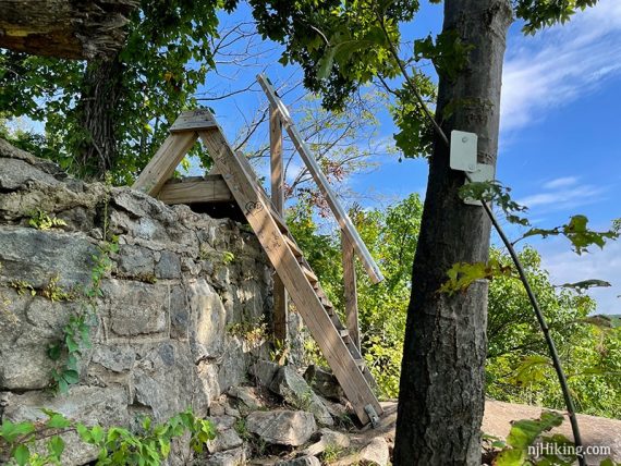 Wooden stile placed as a ladder over a stone wall