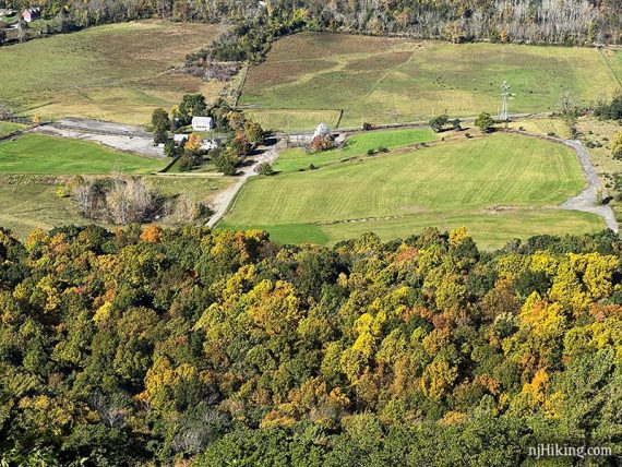 Zoom into a farm and trees with colorful foliage