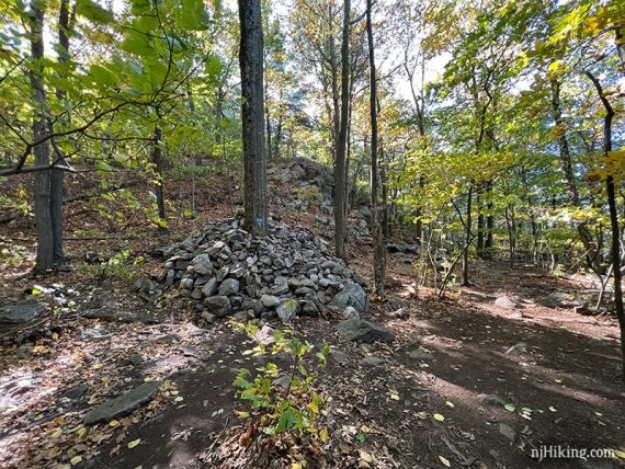 Large pile of rocks at a trail intersection.