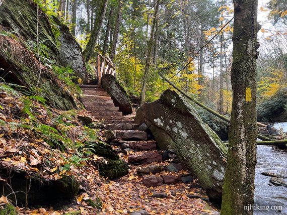 Stone and wooden stairs next to a stream.