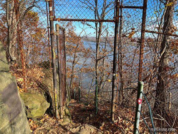 Trail going through a fence gate to cross the NJ-NY border.