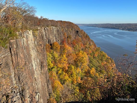 Steep cliffs with colorful foliage on the sides and the Hudson River beyond.