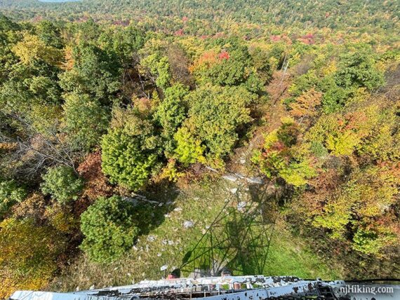 Looking down from a fire tower at the shadow of it on the ground