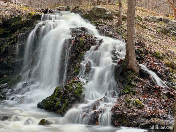 Close up of water falling over a hill and landing in a rocky stream.