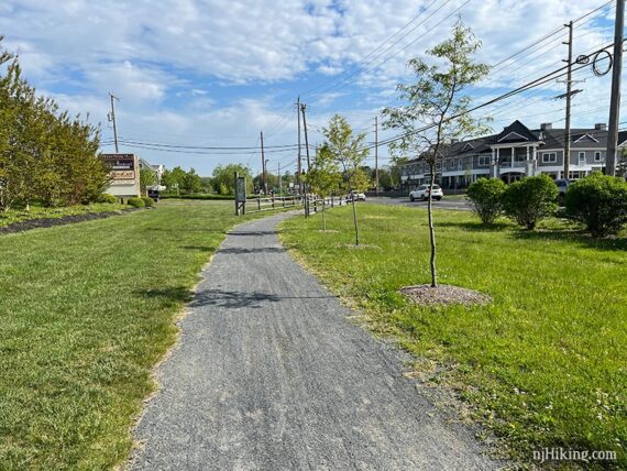 Gravel rail trail nearing a road.