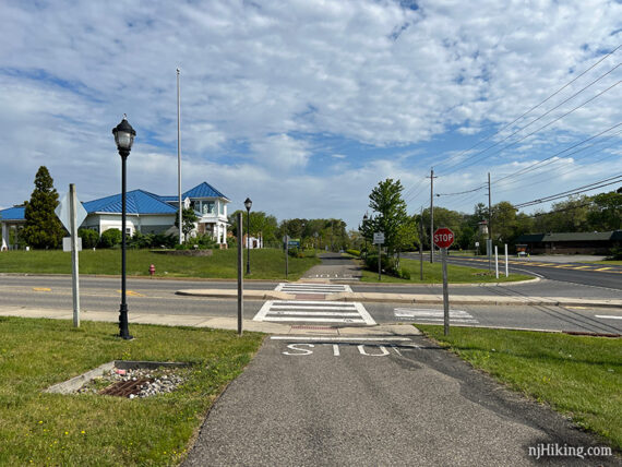 Rail trail crossing a driveway to a shopping center.