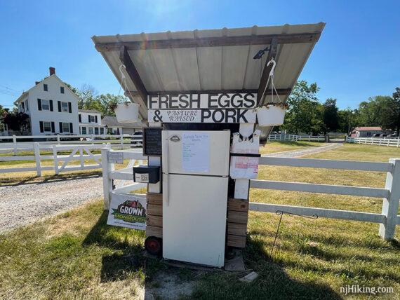 Farm stand near a white fence on a rail trail.