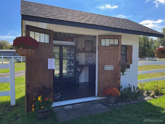 Small shed that contains a farm stand.