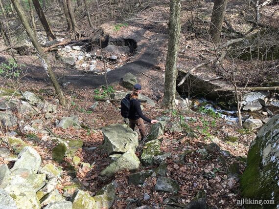 Hiker near rocks and gravel rail line trail