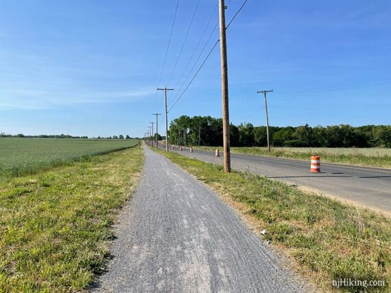 Gravel rail trail running parallel to a road.