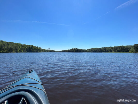 Bright blue lake with a cloudless sky and a roller coaster just visible in the distance.