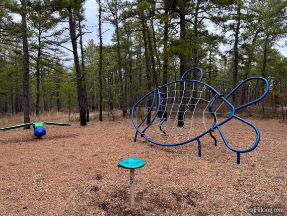 Playground equipment in the shape of a fish with a mesh to climb.