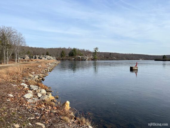 Wide flat trail next to a large lake.