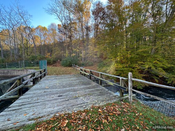 Wide wooden bridge over a mill spillway.