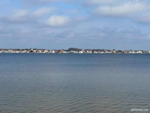 Houses seen in the distance beyond water.