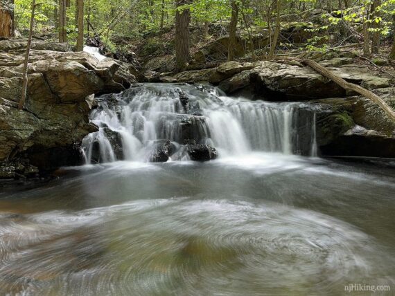 Apshawa Preserve Waterfall tumbling into a pool of water.