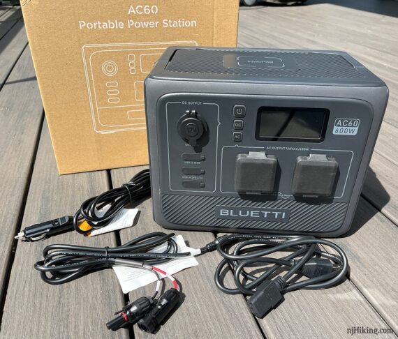 Bluetti AC60 portable power station unit, included cords, and box.