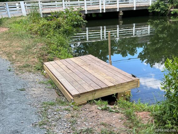 Small wooden platform dock above a canal.