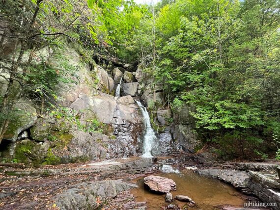 Buttermilk Falls cascading over rocks into a pool of water.