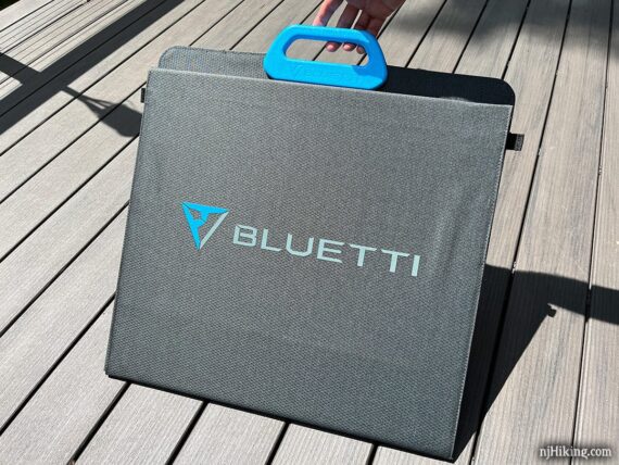 Folded solar panel with blue handle and Bluetti logo.