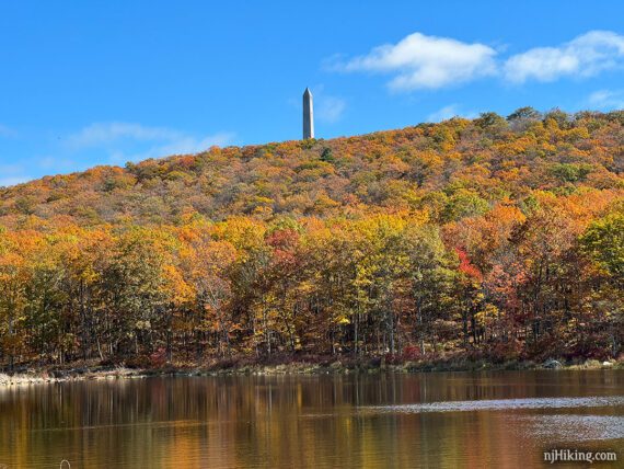 Monument on top of a hill with brightly colored leaves.