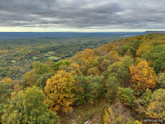 View from a fire tower over orange and yellow fall foliage.
