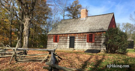 Wick House with a wooden fence and surrounded by fall foliage.