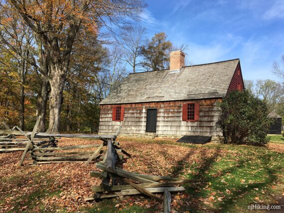 Wick House with a wooden slat fence in front.