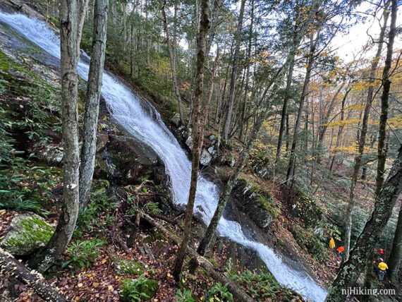 Side view of a waterfall tumbling down a rock face at a steep angle.