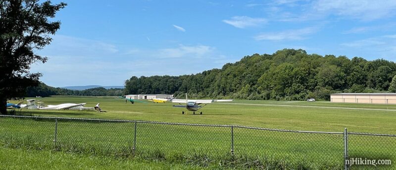 Small planes on green grass at an airport field.