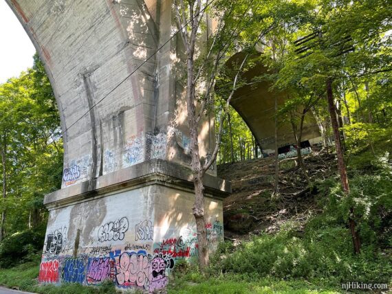 Base of the Paulins Kill Viaduct covered in graffiti.