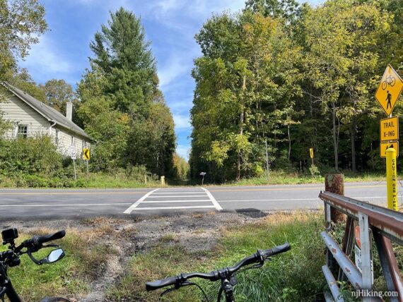 Road crossing on a rail trail with bikes in the foreground.